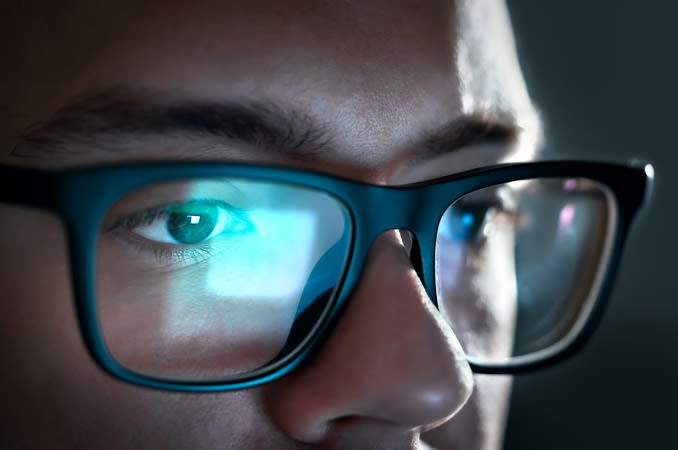 Man wearing computer glasses looking at a computer monitor - India