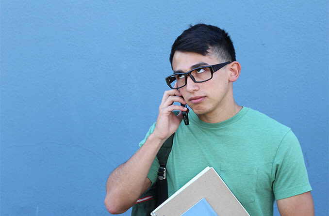 man rolling his eyes while talking on the phone