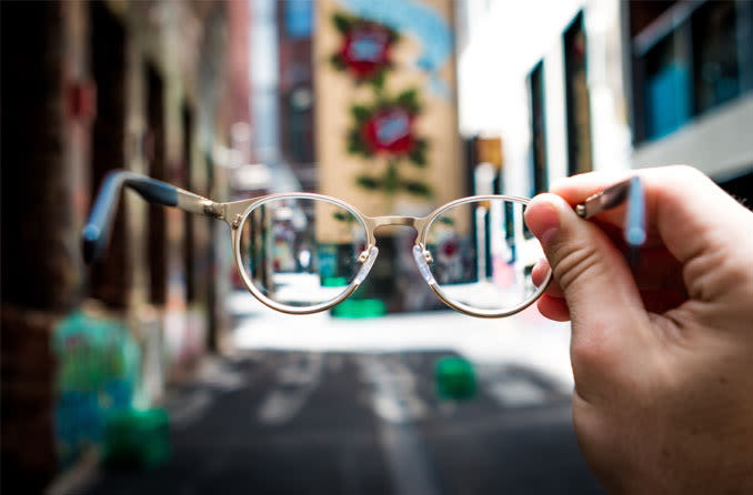 hand holding a pair of spectacles