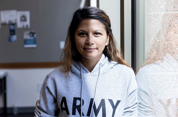 female veteran smiling at camera in front of window