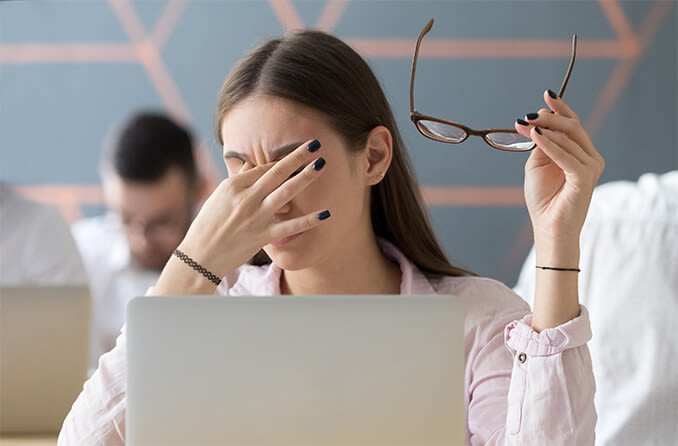 Woman with irritated eyes from prolonged computer use